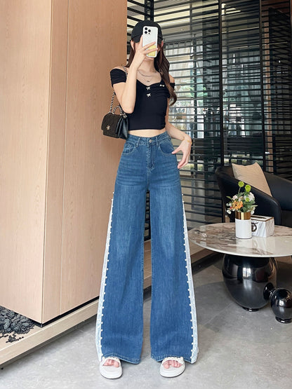 YEEYEEWang 빈티지 블루 와이드레그 진, 아시안핏, 전신 정면 포즈, 얼굴 앞에 휴대폰, 블랙 오프숄더 탑과 체인 백.