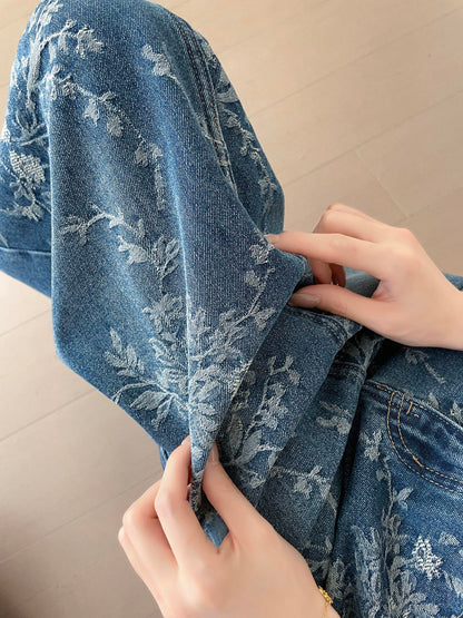 YEEYEEWang 블루 데님 맥시 스커트, 아시안핏, 플로럴 자카드 데님 텍스처 클로즈업, 손으로 원단 가장자리를 들어 조직감을 보여주는 모습.