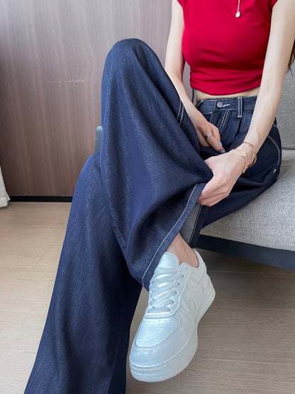 YEEYEEWang 데님 블루 와이드 레그 진, 아시안핏, 허리 아래 소파 앉은 포즈, 한 손으로 밑단을 들어 올린 모습, 화이트 스니커즈 매치.