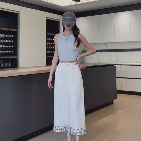 YEEYEEWang Wide-Leg Jeans video in Ivory: Asian model poses hand-on-hip and lifts leg in a modern kitchen, showing high-rise drape and floral hem embroidery.