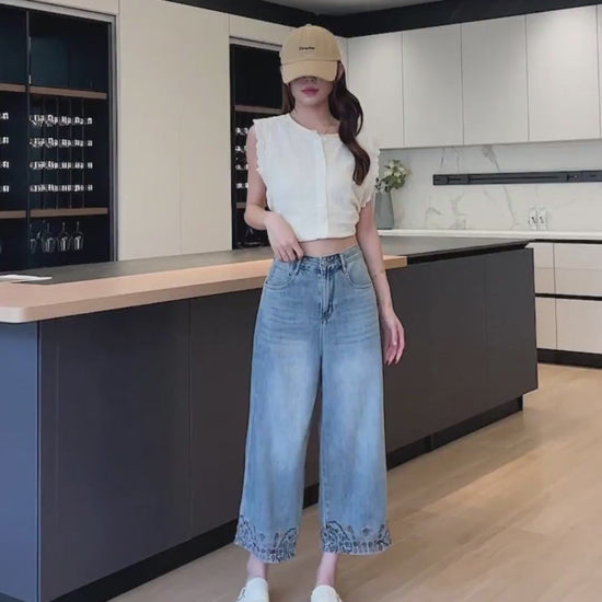 YEEYEEWang Wide-Leg Jeans video in Light Blue: Asian model leans and lifts leg in a modern kitchen, showing high-rise wide-leg drape and floral hem embroidery.